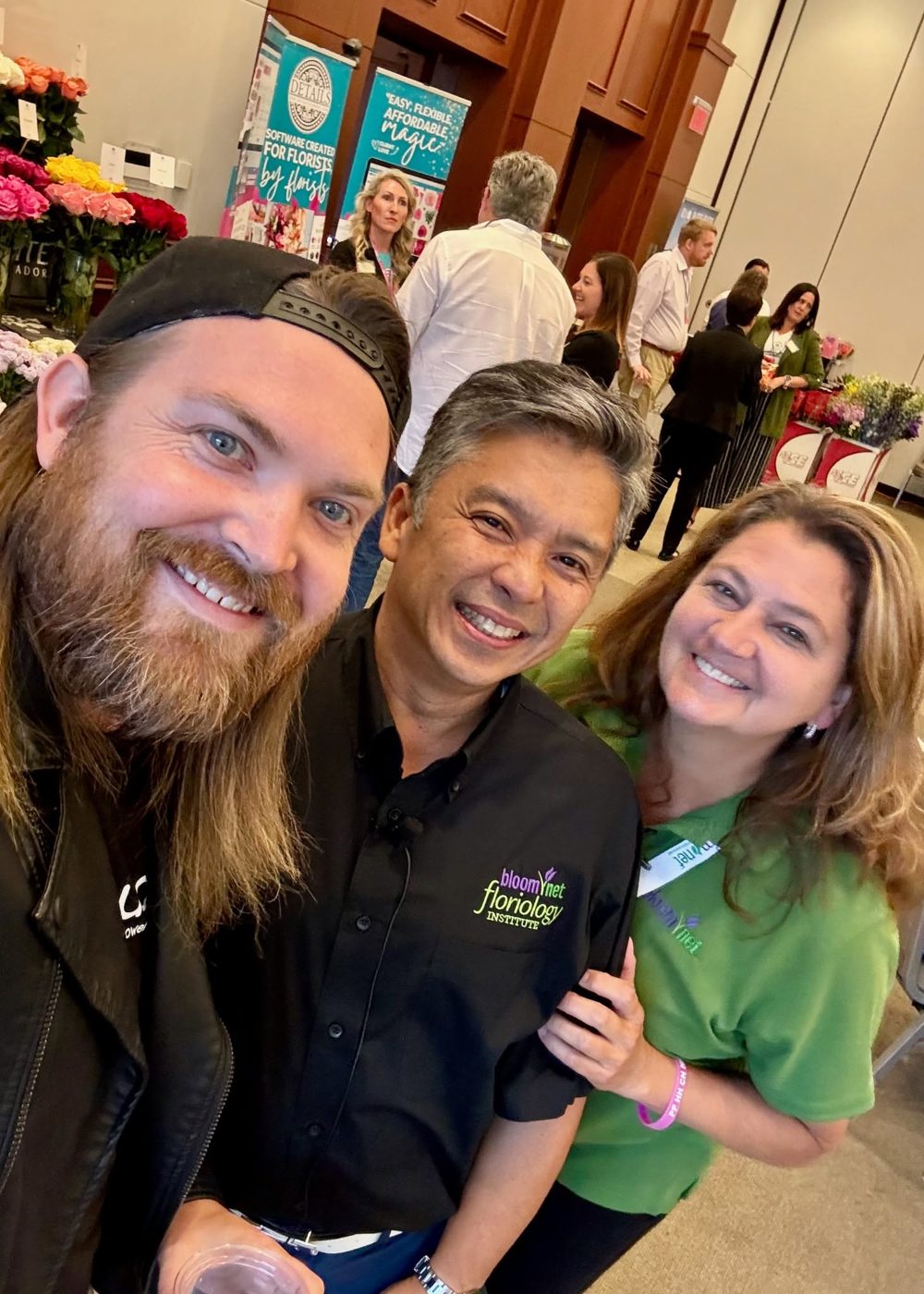 Renato Cruz Sogueco with colleagues on a floral trade show floor