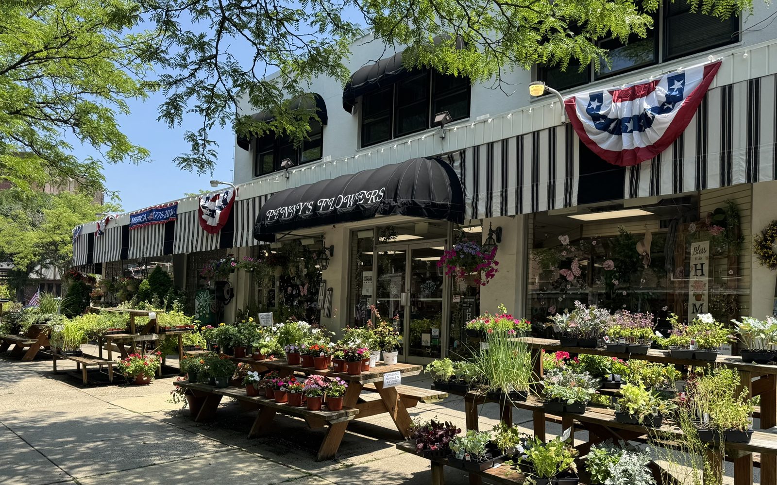 The storefront of Penny's Flowers, with plants and flowers displayed on the sidewalk